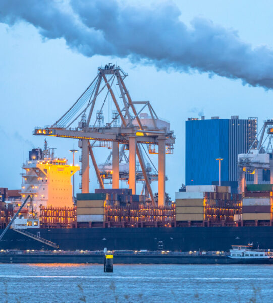 Container ships loading at Europoort tweede maasvlakte harbor in port of Rotterdam Netherlands at dusk during blue hour